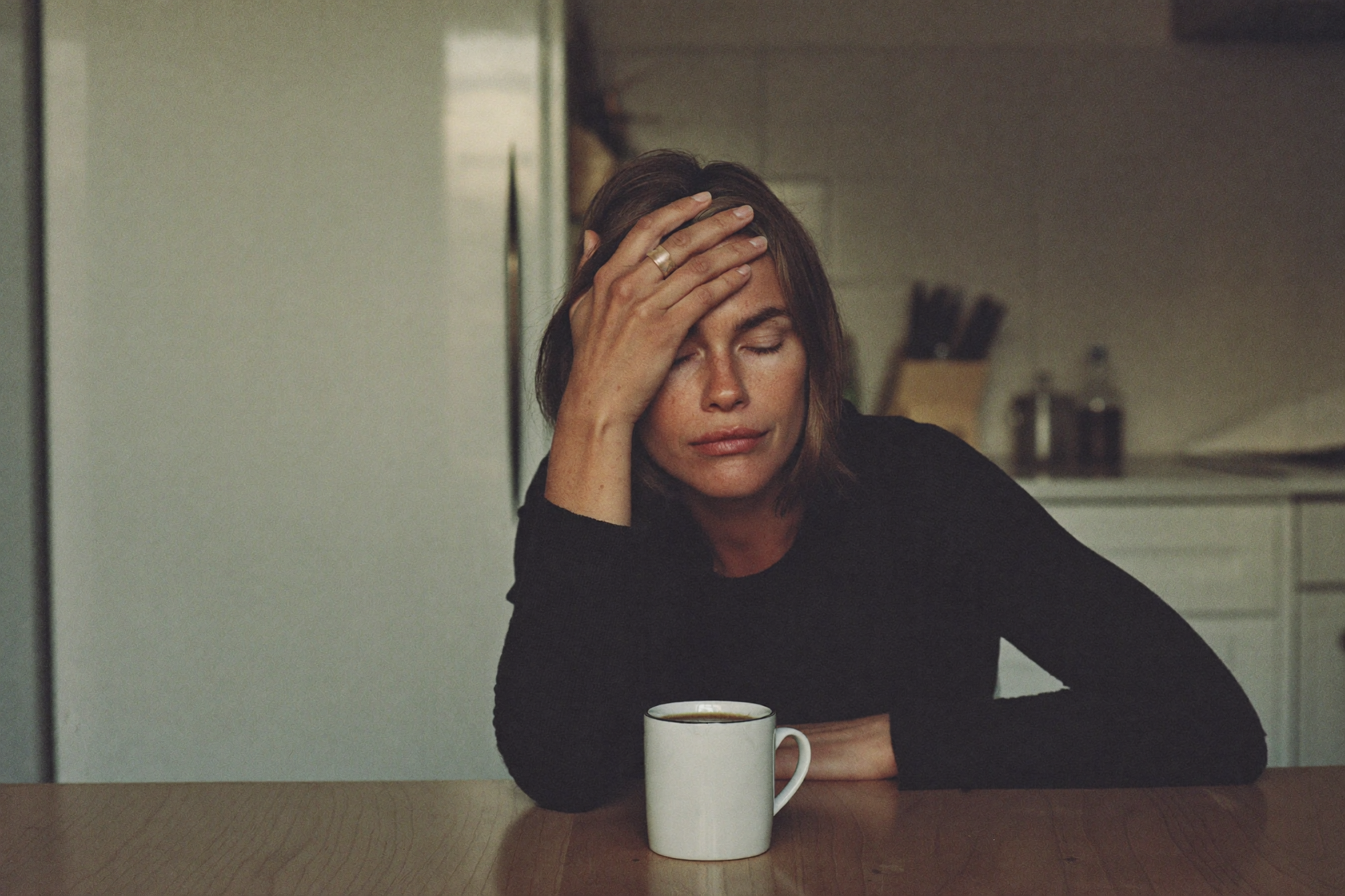 An exhausted woman at a kitchen table