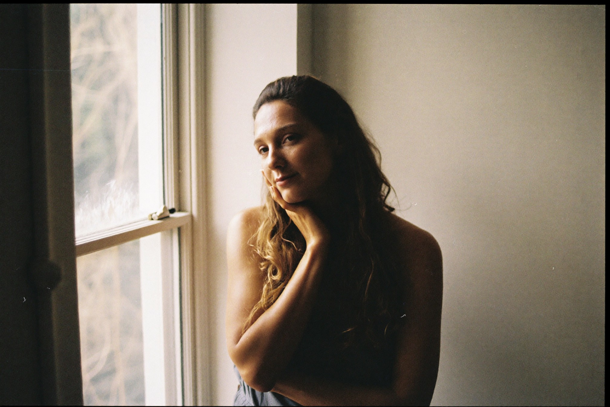 A woman by a window looking away