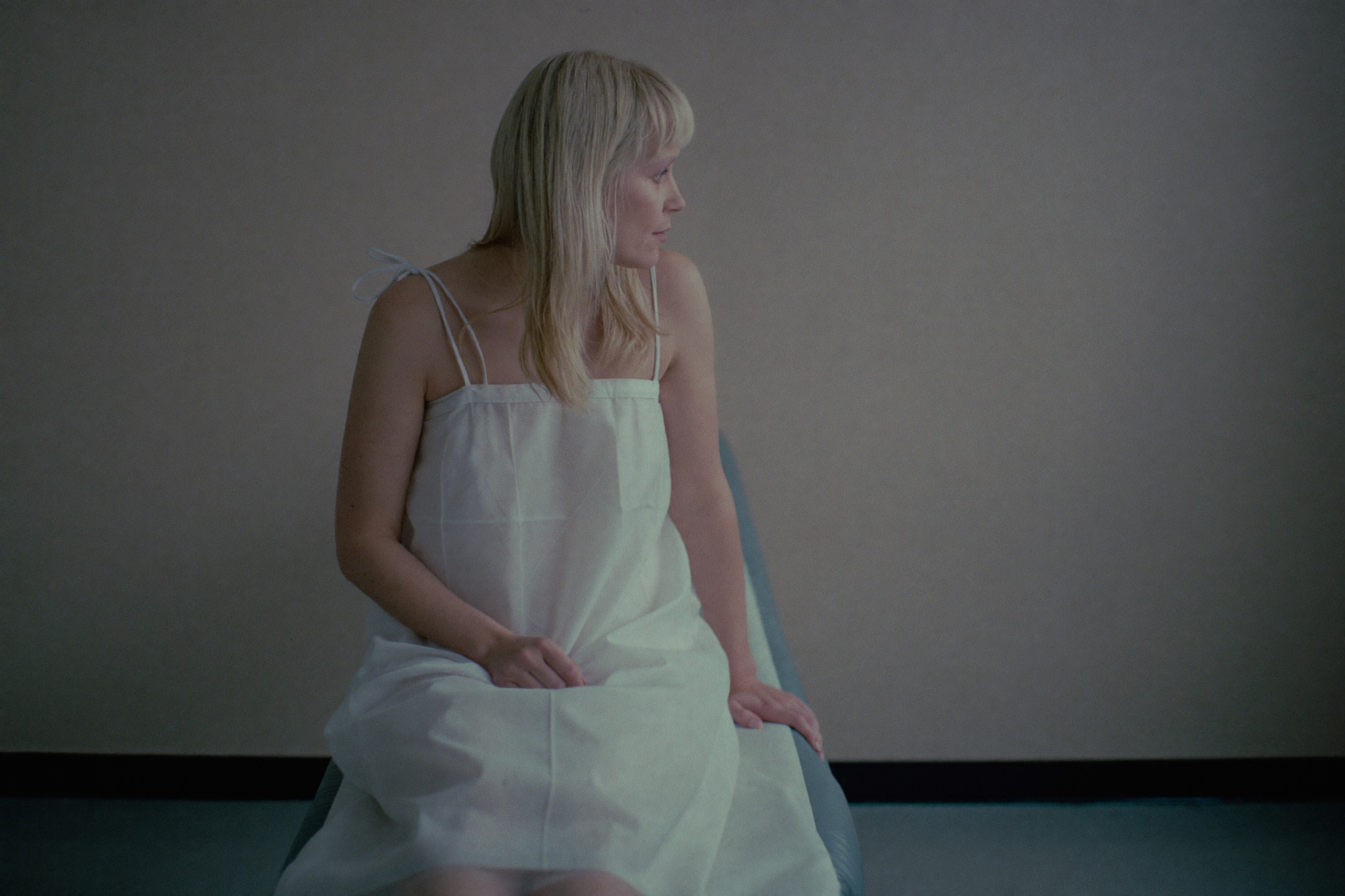 A woman sitting alone on an exam table, waiting